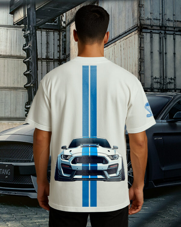 Shelby Mustang T-Shirt featuring blue GT350 car graphic on oversized white t-shirt, worn by model outdoors near Mustang car back view.