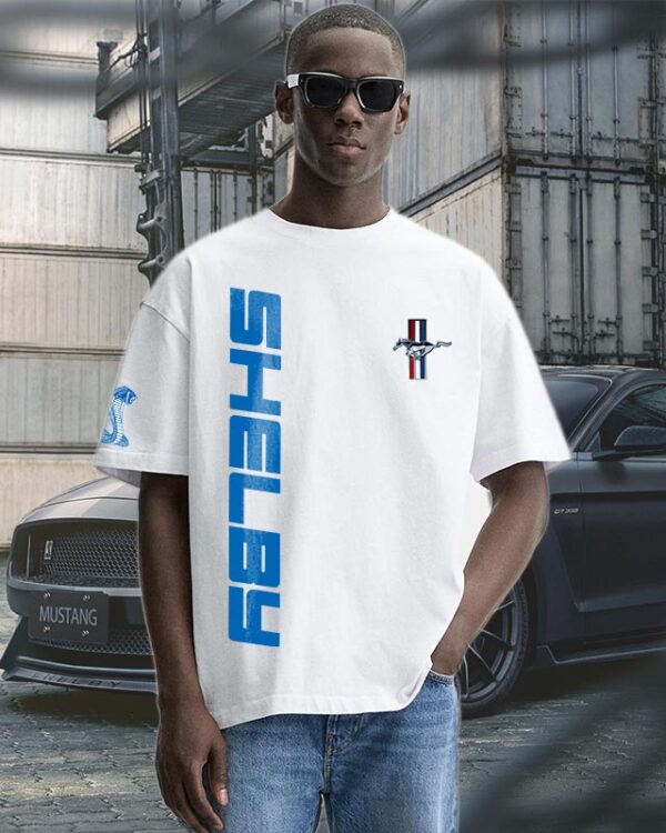 Shelby Mustang T-Shirt featuring blue GT350 car graphic on oversized white t-shirt, worn by model outdoors near Mustang car.